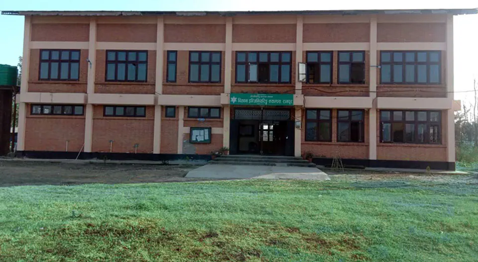 The campus block across its lawn, a long two-storey building with a green door