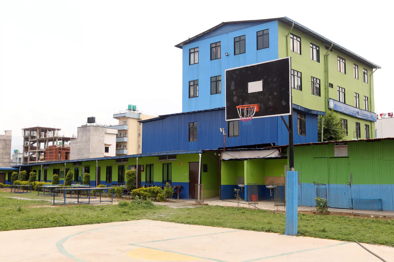 The institute's blue and green three-storey block behind its basketball court