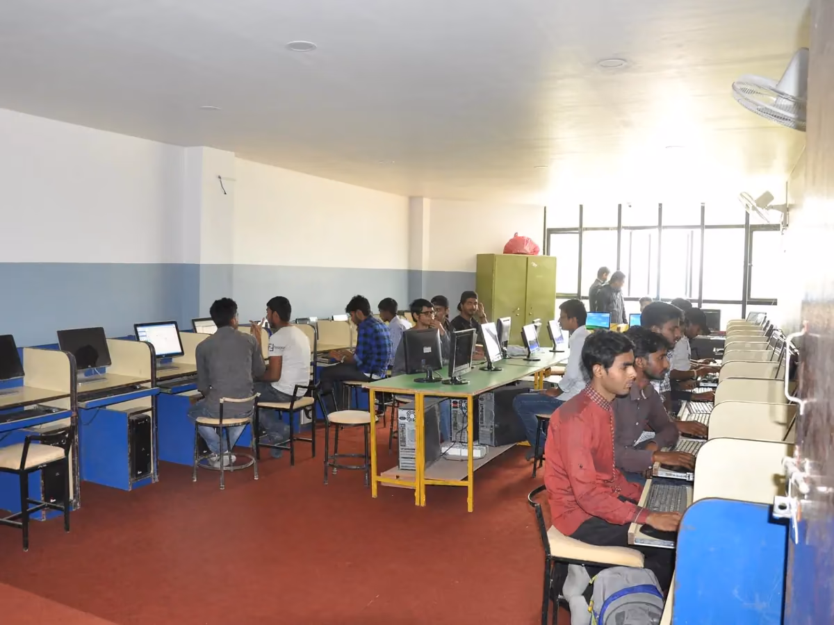 Students at desktop computers along the window wall of the computer laboratory