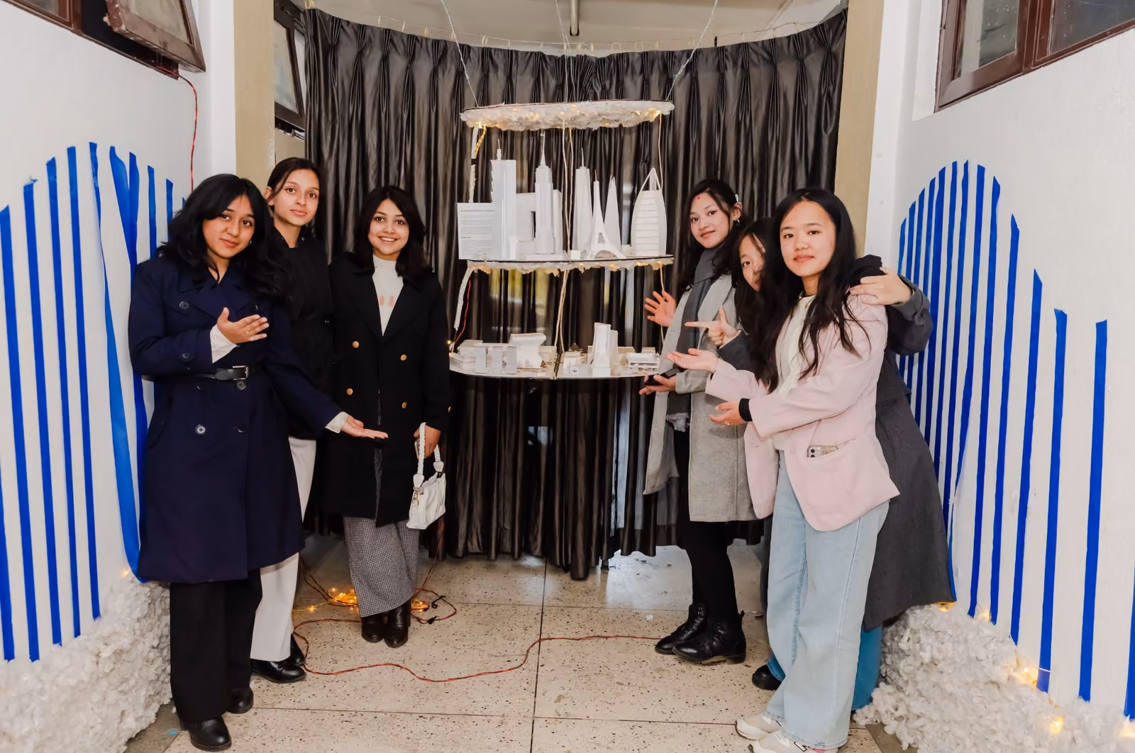 Five students at a decorated stall hung with paper lanterns